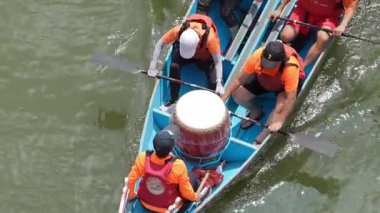 Taipei, Tayvan-08 Haziran 2024: Taipei kürekçisinin yavaş hareketi, kasten raket kaldırışı, gözler odaklı, altın yansımalar suyun etrafında dans ediyor.