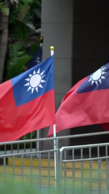 Vertical Slow motion of multiple Taiwan flags arranged in front of a building, emphasizing unity and national pride in an official setting.