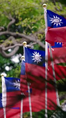 Vertical Slow motion of multiple Taiwan flags arranged under a concrete roof, showcasing patriotism and national pride in an organized urban setting.
