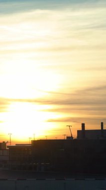 Amsterdam, Hollanda-05 Aralık 2016: Amsterdam Schiphol uluslararası havaalanı günbatımı manzarası. Gündoğumunda turuncu gökyüzü olan modern terminalde uçak bekliyor. Avrupa havaalanları