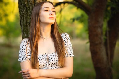 Güneş ışığında uzun saçlı güzel romantik bir kadının portresi yaz parkında doğa üzerinde yürüyor.