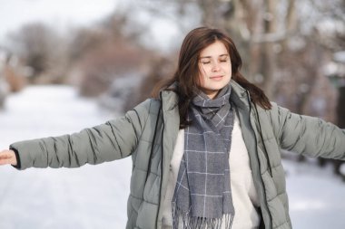 pretty young woman in winter clothes walks outdoors, girl enjoying beautiful nature clipart