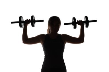 Elinde dambıllar olan genç bir kadının silüeti beyaz izole bir arka planda, spor, güzellik ve sağlık kavramı ile meşgul olan bir kız.