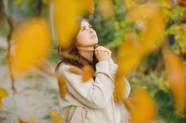Genç kadın sonbahar yolunda duruyor ve ellerini kavuşturup Tanrı 'ya dua ediyor. Ruhunu, konsept dini ve yaşam tarzını döküyor.