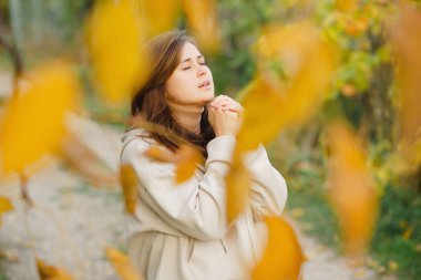 Genç kadın sonbahar yolunda duruyor ve ellerini kavuşturup Tanrı 'ya dua ediyor. Ruhunu, konsept dini ve yaşam tarzını döküyor.