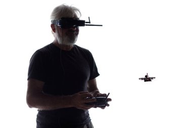 Gözlüklü, siluetli adam yarış aracını kontrol ediyor.