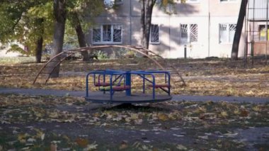 Şehirde sonbahar. Boş çocuk parkı. Atlıkarınca dönüyor. Güneşli sıcak bir gün. Harkiv, Ukrayna, savaştan önce. Yüksek kalite 4k görüntü