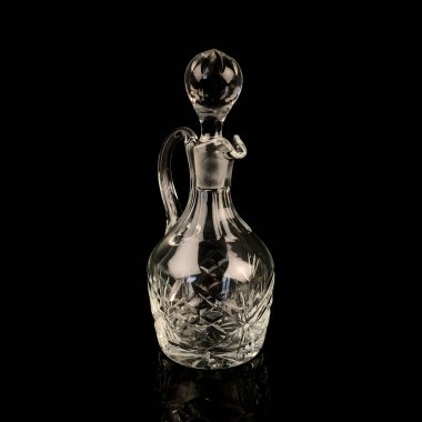 Geometrik desenli antika cam sürahi. Siyah izole edilmiş arka planda alkolün retro sürahisi. Oymalı vintage sürahi