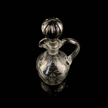 Geometrik desenli antika cam sürahi. Siyah izole edilmiş arka planda alkolün retro sürahisi. Oymalı vintage sürahi