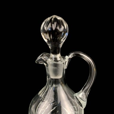 Geometrik desenli antika cam sürahi. Siyah izole edilmiş arka planda alkolün retro sürahisi. Oymalı vintage sürahi