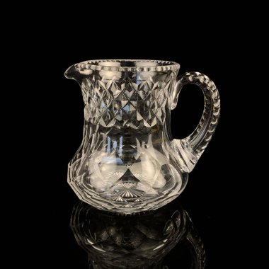 Geometrik desenli antika cam sürahi. Siyah izole edilmiş arka planda alkolün retro sürahisi. Oymalı vintage sürahi