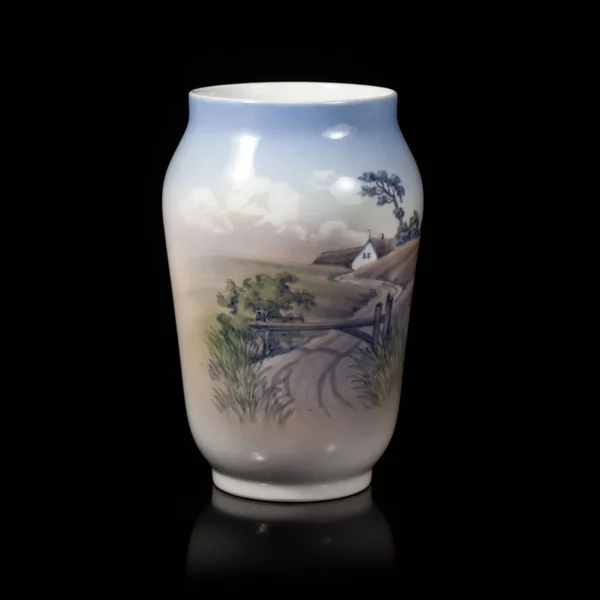 beautiful blue vase depicting a landscape on a black isolated background. antique porcelain vase with painting. village landscape