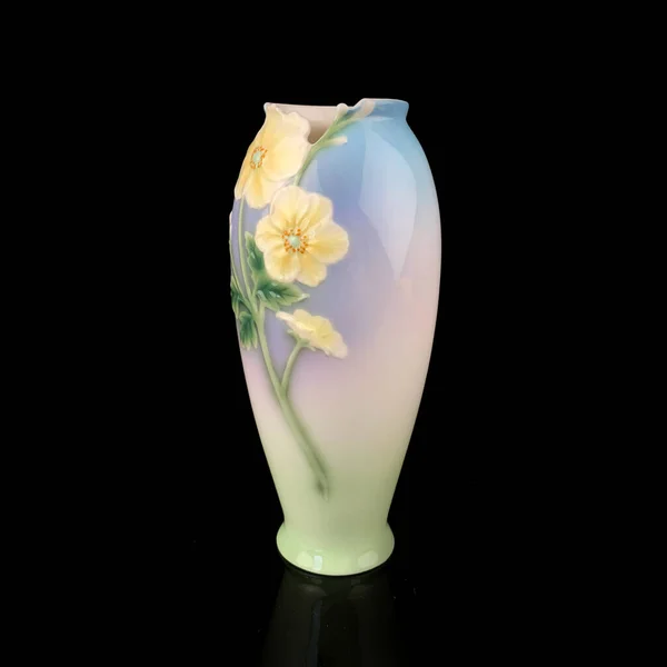 blue vase with a flower pattern on a black isolated background. antique porcelain vase with painting