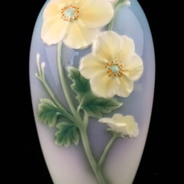 blue vase with a flower pattern on a black isolated background. antique porcelain vase with painting