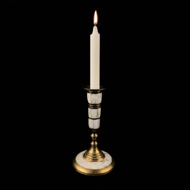 candle in an antique candlestick. candle. golden candlestick of unusual shape