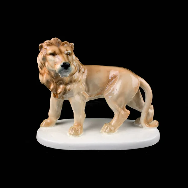 Lion ceramic statuette isolated on black background with clipping path. antique porcelain lion figurine