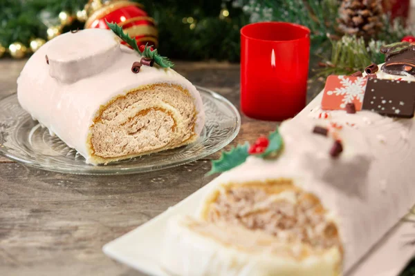 木制桌子上挂着圣诞彩灯的白色巧克力蛋黄酱蛋糕 — 图库照片