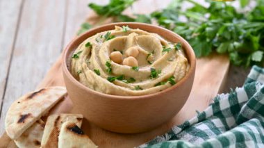Tahta masadaki humus kasesine zeytinyağı dökerek.