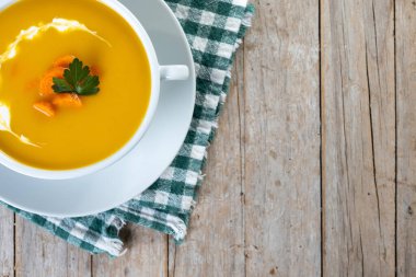 Havuç çorbası kremalı ve maydanozlu ahşap masa manzaralı. Boşluğu kopyala