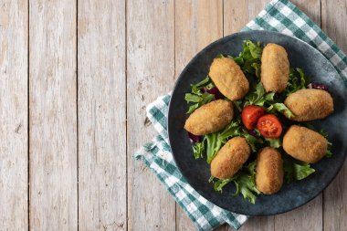 Traditional spanish fried croquettes on wooden table. Top view. Copy space