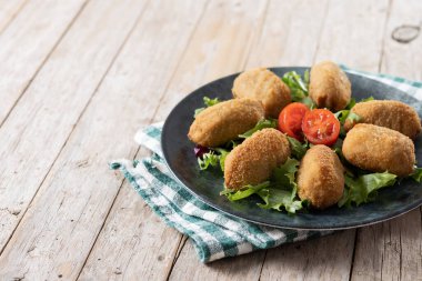 Traditional spanish fried croquettes on wooden table. Copy space