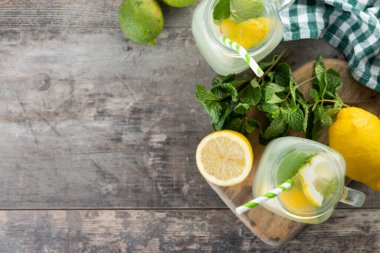 Kavanoz bardakta limonata ve ahşap masadaki malzemeler. Üst Manzara. Boşluğu kopyala