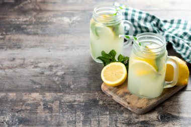 Kavanoz bardakta limonata ve ahşap masadaki malzemeler. Boşluğu kopyala