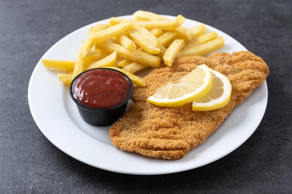 stock image Wiener schnitzel with fried potatoes on black slate surface.typical vienna food