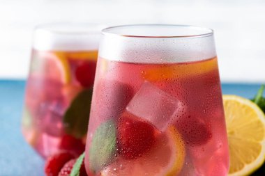 Mavi arka planda ahududulu limonata içeceği. Kapat.