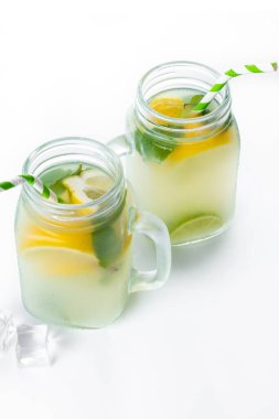 Kavanozda limonata içilir ve malzemeler beyaz arka planda izole edilir.