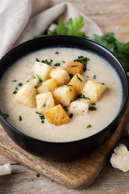 Karnabahar çorbası ahşap masada bir kase içinde
