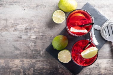 Cape Codder kokteyli, votka, kızılcık suyu ve ahşap masada limon.