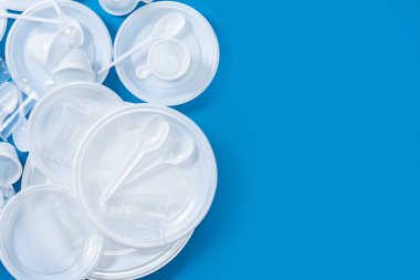 Mavi arka planda tek kullanımlık plastik. Üst Manzara. Boşluğu kopyala