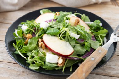 Ahşap masada elmalı ve cevizli sonbahar salatası
