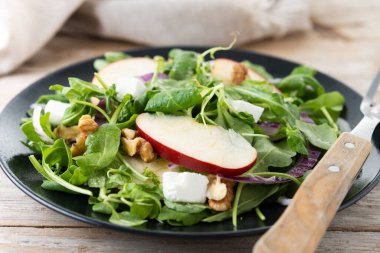 Ahşap masada elmalı ve cevizli sonbahar salatası