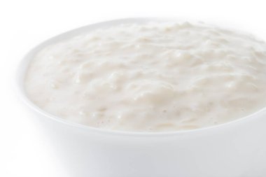 Sütlaç. Arroz con leche. Beyaz arka planda izole edilmiş beyaz kasedeki sütlaç. Kapat.