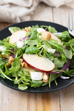 Ahşap masada elmalı ve cevizli sonbahar salatası