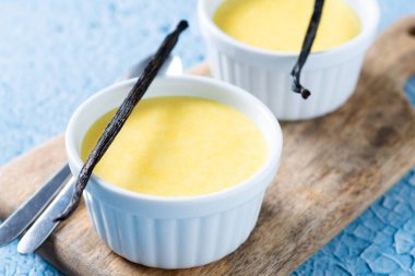 Mavi arka planda ev yapımı vanilyalı krema.