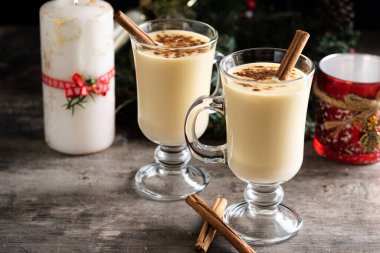 Ahşap masada tarçınlı ev yapımı eggnog. Tipik Noel tatlısı. Boşluğu kopyala