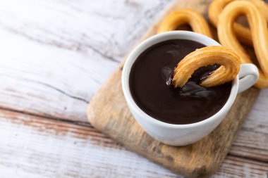 Geleneksel İspanyol churro 'ları sıcak çikolatalı kahvaltı ve ahşap masa. Boşluğu kopyala