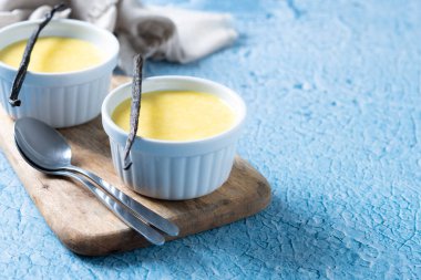 Mavi arka planda ev yapımı vanilyalı krema. Boşluğu kopyala