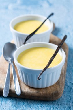 Mavi arka planda ev yapımı vanilyalı krema.