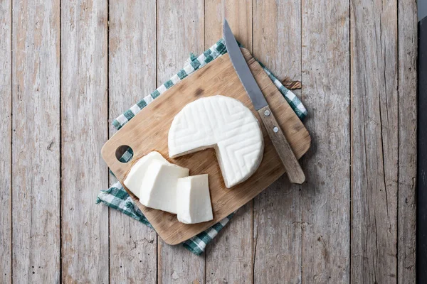 Sliced fresh white cheese from cow\'s milk on wooden table. Top view