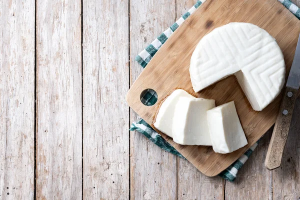 Sliced fresh white cheese from cow\'s milk on wooden table. Top view. Copy space