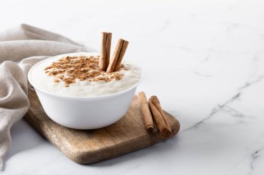 Arroz con leche. Beyaz mermer üzerinde tarçınlı sütlaç. Boşluğu kopyala