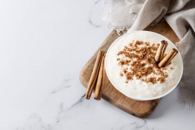 Arroz con leche. Beyaz mermer üzerinde tarçınlı sütlaç. Üst Manzara. Boşluğu kopyala