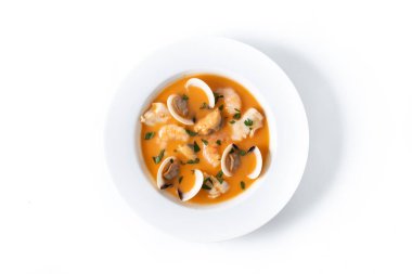 Beyaz arka planda yalıtılmış deniz ürünleri çorbası tabağı. Üst görünüm