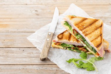 Jambonlu, peynirli, domatesli ve roka aromalı sandviç. Boşluğu kopyala