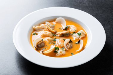 Siyah arkaplanda deniz ürünleri çorbası tabağı