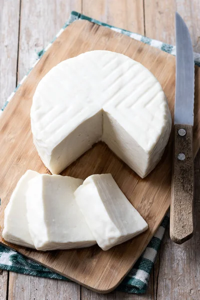 Sliced fresh white cheese from cow\'s milk on wooden table